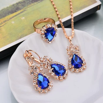 Női gyönyörű ékszerkészlet csillogó strasszokkal, kék ékszerekkel körülvéve design medál nyaklánc / fülbevaló / gyűrűk